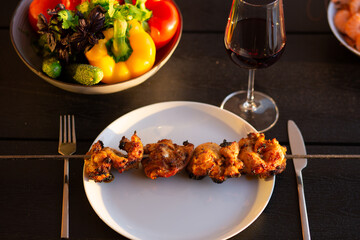 A picnic on the terrace for friends.Terrace with barbecue at sunset.Fried meat on the street at home. Kebab.Grilled meat is served at home.Grilled meat with wine and vegetables.Summer on the terrace.