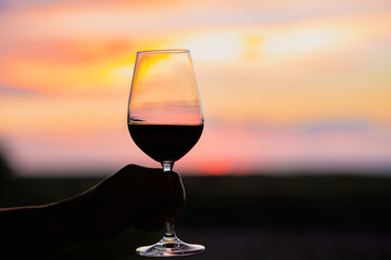 Sunset with a glass of wine.Beautiful sky with sunset with a glass of wine.A glass of wine at sunset in the mountains.Red wine. Relax.Summer concept.Summer with sunset.August. Summer vacation 
