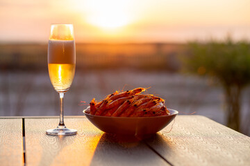 Shrimps with beer at sunset near the sea. Summer. Shrimp with champagne at sunset Summer concept. Seafood with beer. Sea sunset with champagne. Beautiful sunset. Cold beer with shrimps. King prawns 