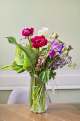Bouquet of bright flowers on the table in jug
