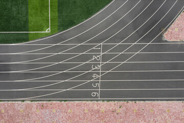 Aerial top view of grey runway of track and field starting line