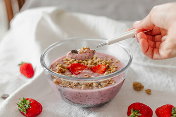 Chia strawberry pudding and coconut milk in a glass bowl. Healthy breakfast. Vegan recipe