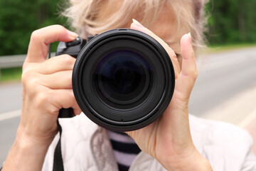 Close up of a camera lens in female hands.