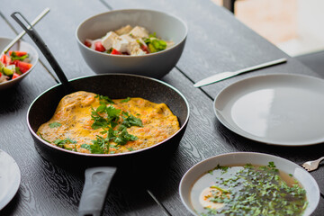 Breakfast outside. Shrimp omelet for breakfast. Omelet in a frying pan for breakfast. Lunch for a man. Fried omelet with vegetables. Summer food on the street. Egg soup. Regular food. Diet. Bouillon
