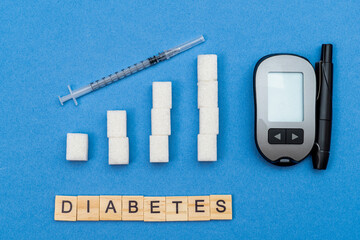 growing, increasing sugar columns, graph, syringe and word diabetes on blue background