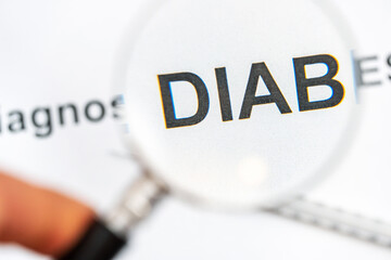 Words diabetes diagnosis with syringe through magnifying glass.