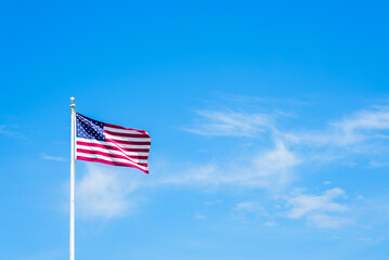 Amaerican flag on pole with blue sky - Powered by Adobe