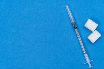 sugar, syringe on blue background. Testing, treatment diabetes concept.
