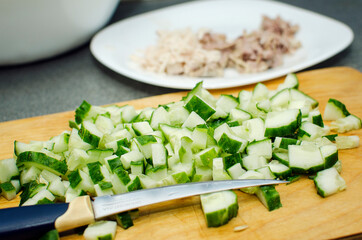 Fresh cucumbers are cut into cubes. Salad ingredients. Healthy food.