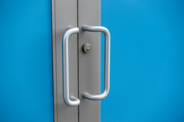 silver door handles outside of a business building, with a blue screen effect