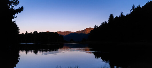 Obraz premium Panoramic landscape of beautiful sunrise or sunset on an alpine lake in the Pyrenees, Catalonia, Spain. Concept of vacations, summer, relaxation and disconnection in nature. Wilderness.