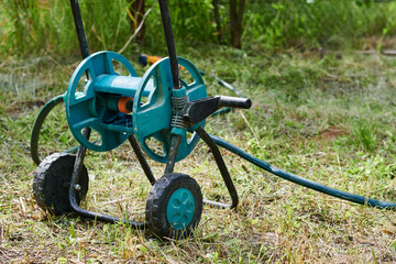 Green babin with watering hose, compact garden tool