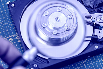 Fototapeta na wymiar hard disk drive through a magnifying glass, information search, diagnostics, restore