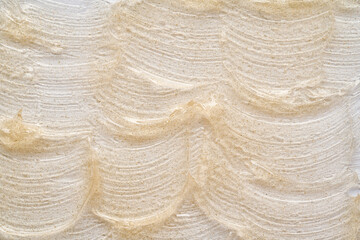 Transparent smear and texture of golden cosmetic gel on a white background.