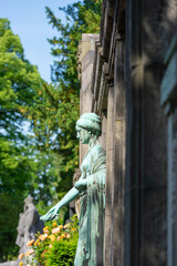 Trauernde Frau vor einem großen Familiengrab