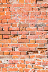 Vertical background with old red brick wall on a sunny day