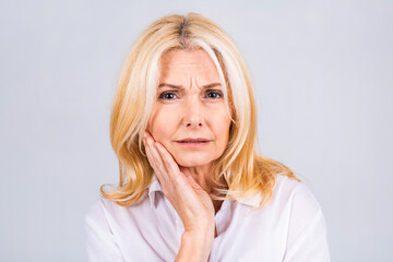 Beautiful senior aged mature woman touching mouth with hand with painful expression because of toothache or dental illness on teeth. Dentist concept.