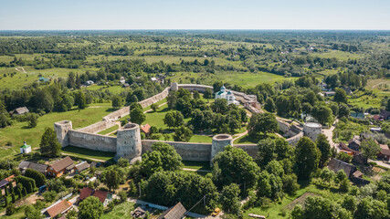 Fototapeta na wymiar Aerial view of Izborsk fortress in Russia. Semi-ruined walls, towers and courtyards around a 14th-century fortress