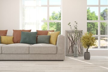 White living room with sofa and summer landscape in window. Scandinavian interior design. 3D illustration