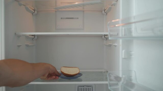 Hungry Man Opens the Empty Refrigerator and Takes the Leftover Bread. Poverty and Economic Crisis Concept. No Money or Food. Shooting from the First Person. POV