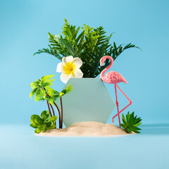 Summer weekend party concept. Flamingo, palms and tropical flower on blue background.