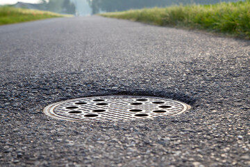 closeup of a manhole cover in asphalt