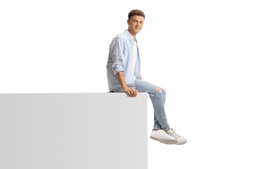 Young trendy man sitting on a white wall - Powered by Adobe