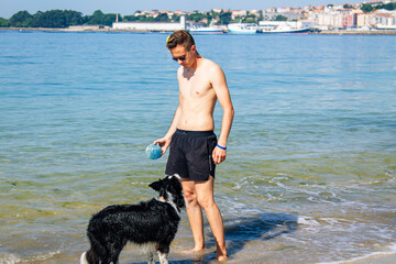 man on the beach shore playing with his pet