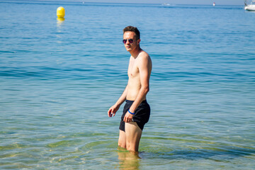 handsome young man bathing on the beach