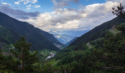 view from the forest of a village among the mountains and under the blue sky