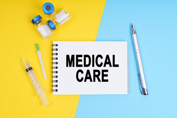 A syringe, ampoules and a notebook with the inscription - MEDICAL CARE