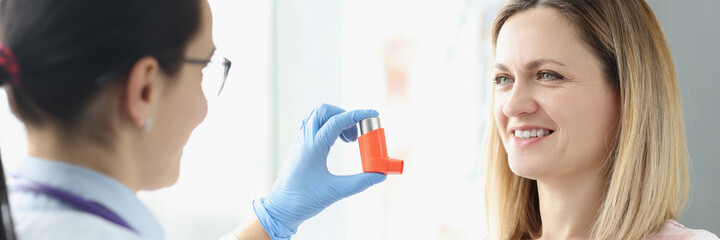 Woman holds an asthma inhaler in her hand