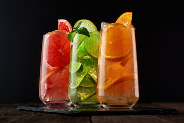 Mix of three ice refreshing drinks with orange, lime and grapefruit Cold refreshing cocktails - a...