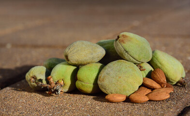 close-up of green fresh almonds, which are still lying on a stony surface with their shell and shell