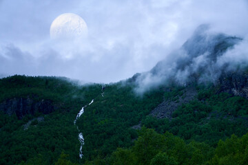 Digital art. Natural landscape with fog and mystical planet or moon.