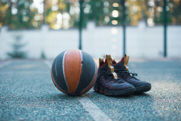 Basketball ball, sportive shoes for workout on basketball court, close up advertising photography...