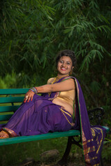 Beautiful Indian young girl in Traditional Saree posing outdoors