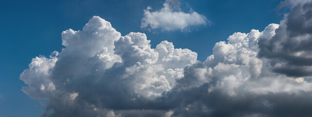  Beautiful cumulus clouds against the blue sky.. Panoramic shot of a cloud cluster. Wide format.