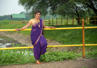 Beautiful Indian young girl in Traditional Saree posing outdoors