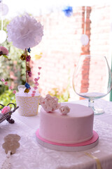 Torta en mesa de cumpleaños, con copa de vino y adornos en papel 