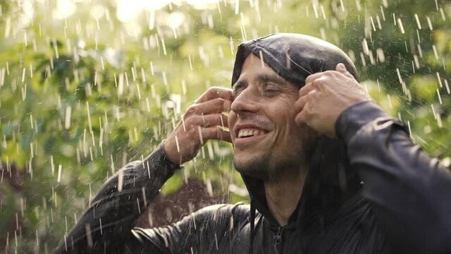 Cheerful young man under rain