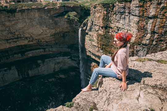 Beautiful girl posing on rocks near the water. 