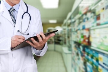 Hands of young pharmacist checking inventory in medical store using a digital tablet