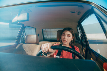 Woman in casual wear looking at the window while driving a car