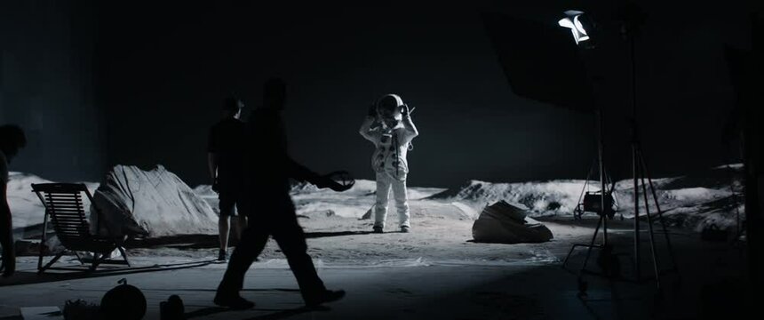 WIDE Cinematographer talking to an actor on a moon landing scene TV commercial shooting set. Virtual production with LED screens. Shot with 2x anamorphic lens