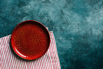 Kitchen background. Red ceramic plate on a blue background. copy space