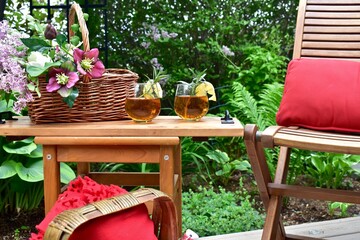Backyard garden oasis with beautiful bouquet of seasonal cut flowers and glass of ice tea beverage...
