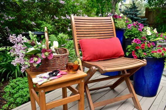 Backyard garden oasis with beautiful bouquet of seasonal cut flowers and glass of ice tea beverage for relaxing and enjoying secluded quiet time on warm summer afternoon staycations