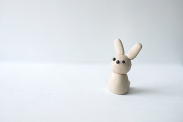 figurine of a bunny from plasticine on a light background