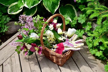 Backyard garden oasis with garden tools and cut flower bouquet of seasonal blooms arranged in...